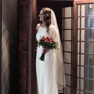 A bride by a phone booth.