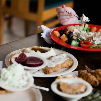Southern chicken fried steak served with mashed potatoes, pickled beets, and a fresh salad.