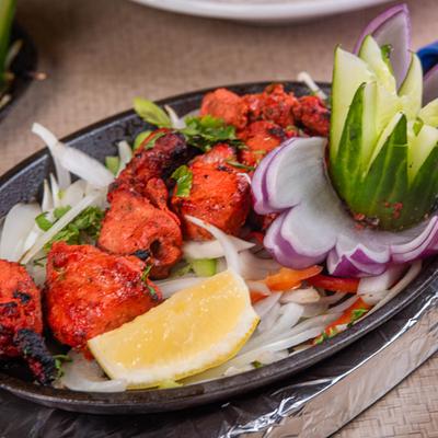 Sizzling red tandoori chicken chunks served on bed of onions with lemon.
