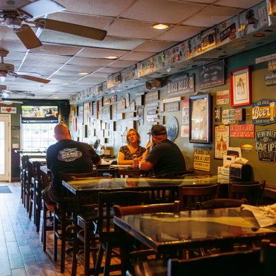 Interior featuring rustic decor, tiled ceilings and patrons seated at wooden tables.