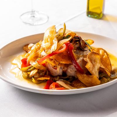 Grilled pork chop, with potatoes, onions, and peppers.