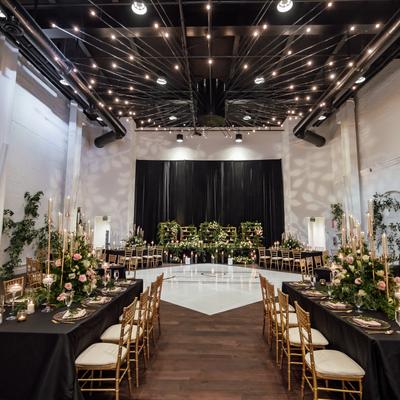 Tables set for a large reception indoors.
