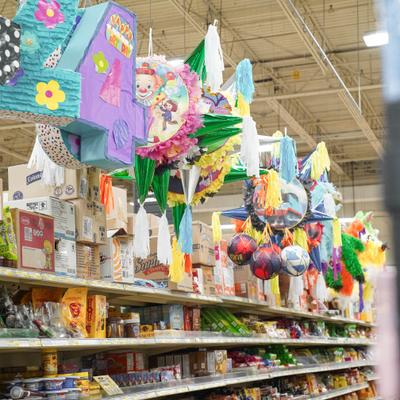 Store aisle displaying various colorful pinatas and Mexican candies.