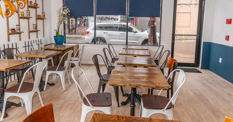 Interior, tables and chairs with large window in the back