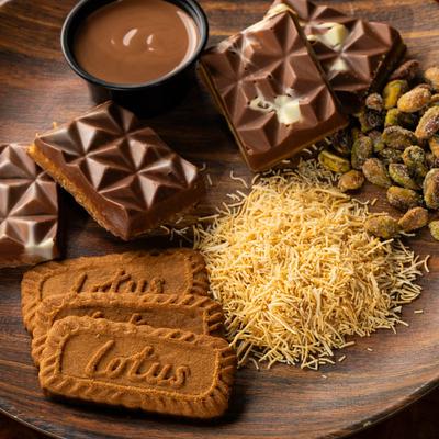 Milk chocolate bars, Biscoff biscuits, a chocolate dip, pistachios, and shredded phyllo dough.