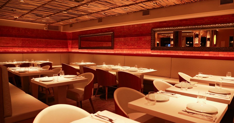 Interior, dining area, tables ready for guests, red brick walls, long mirrors on the walls