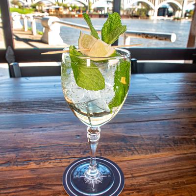 Hugo Sprit served in a large wine glass, garnished with mint and a lime wedge.