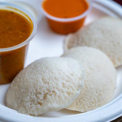 Steamed rice cakes served with a lentil vegetable stew and chutneys.