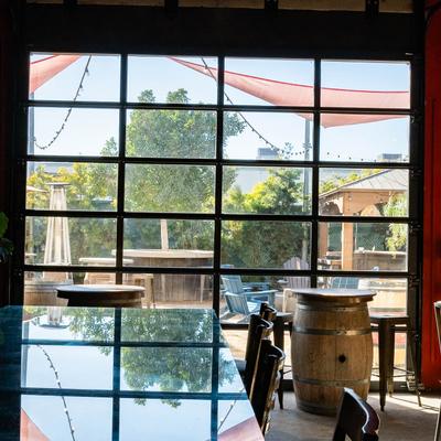 Outdoor seating area seen through a large industrial-style window.