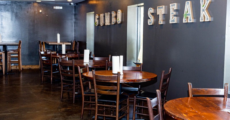 Interior, round wooden tables and chairs by a wall