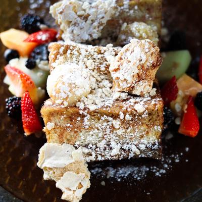 Thick-cut French toast with hazelnut spread, peanut butter, powdered sugar, and fruit.