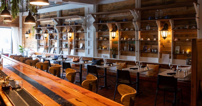 Seating area with banquet seating, bar chairs, and shelves with decorative objects