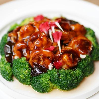 Shrimp with sauce and broccoli on a plate.