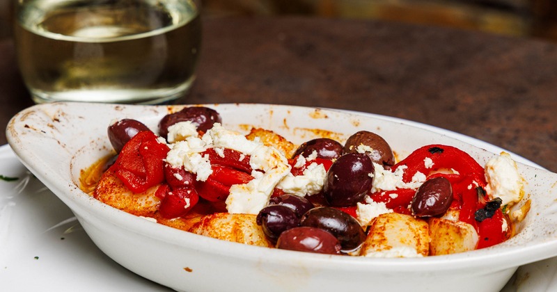 Baked scallops topped with cheese, peppers and olives
