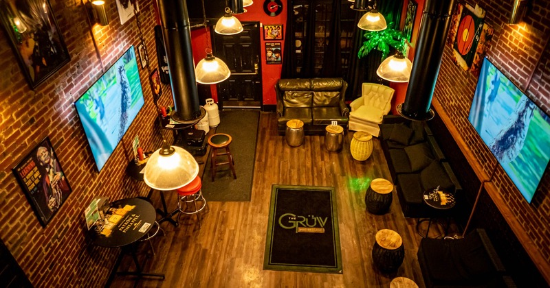 Interior, overhead view, black sofas, tv screen on the walls