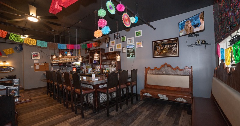 Colorful Mexican interior with bar and high wooden chairs.
