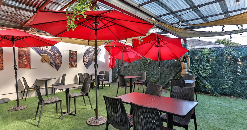 Covered patio, tables, chairs and red parasols