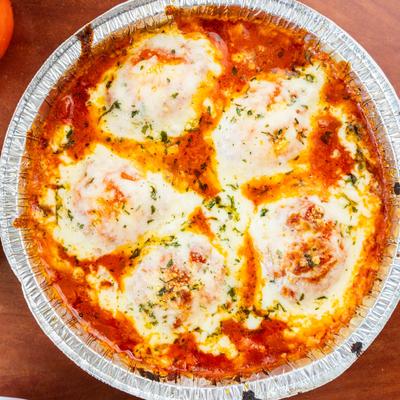 Baked cheese ravioli with marinara sauce and mozzarella, top view.