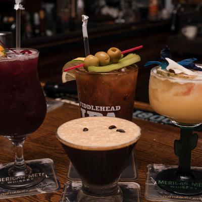 Various cocktails served on a wooden bar counter.