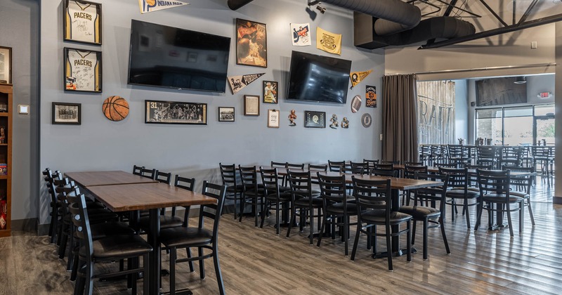Interior, dining area, long setup wooden top tables for twelve people, TVs on the wall
