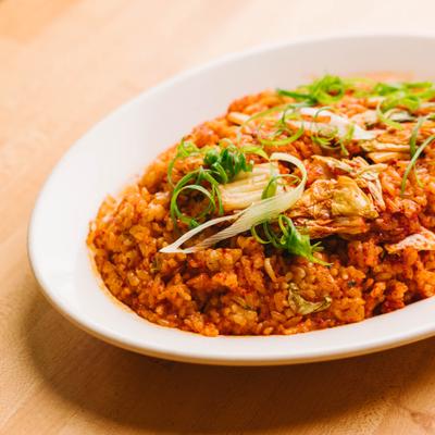 Fried rice topped with herbs on a plate.