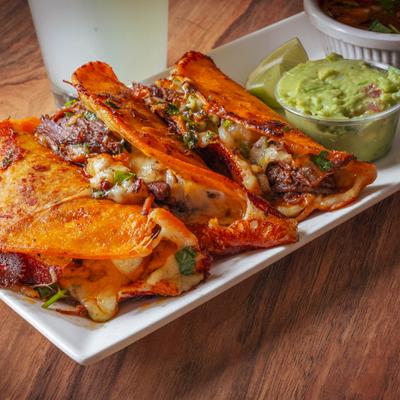 Birria tacos with sides, close-up.