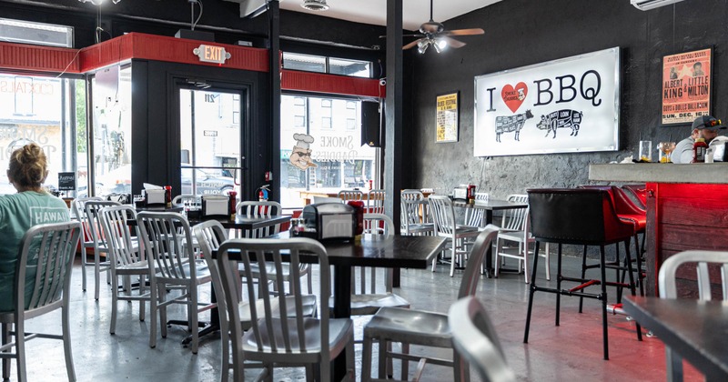Interior, black walls, red accents, metal chairs, ceiling fans, and sign