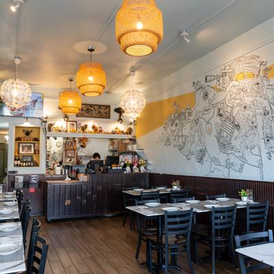 Dining area with seating space, counter area and wall mural featuring elephant illustrations.