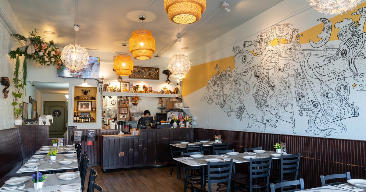 Cozy interior with tables, chairs, a whimsical mural and decorative lighting.
