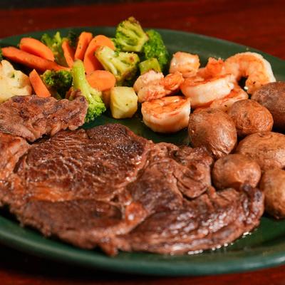 Grilled steak, shrimp, potatoes, and veggies.