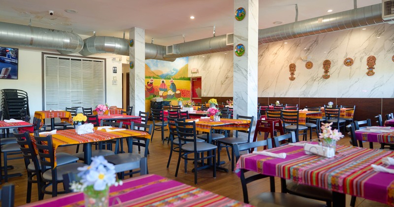 Dining room decorated with colorful textiles and Andean-themed wall art