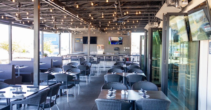 Covered patio, tables ready for guests, TVs on the walls