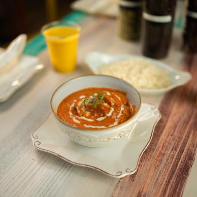 Butter chicken served with rice and mango lassi.