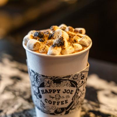 Hot Chocolate topped with numerous heavily toasted marshmallows, close-up.