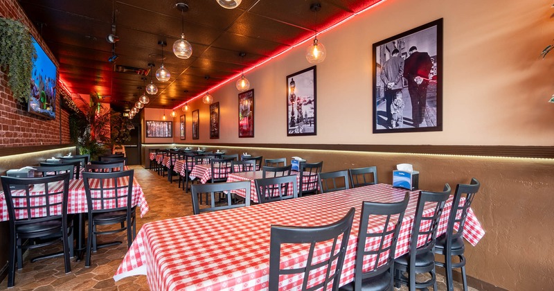 Interior dining area with checkered tablecloths, black chairs and hanging spherical lights