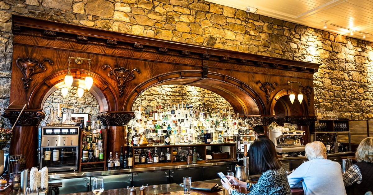 Bar, guest, drink rack behind, wide view