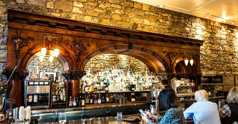 Bar, guest, drink rack behind, wide view