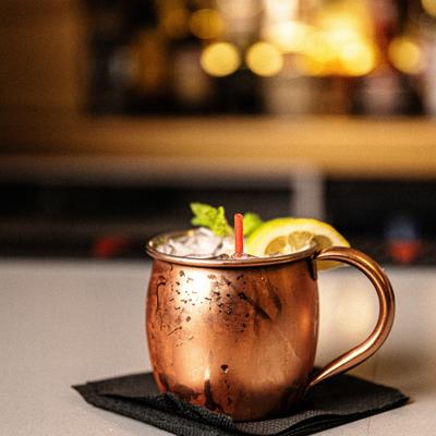 Moscow Mule served in a copped mug, garnished with mint and a slice of lemon.