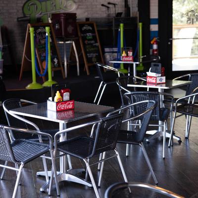 Interior with tables, chairs, and condiments.