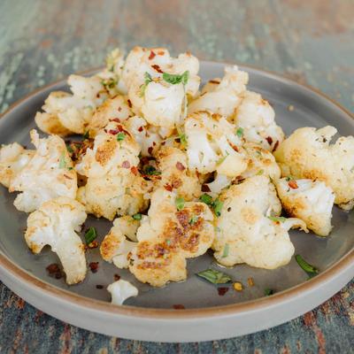 Roasted Cauliflower florets, toped with chili flakes and herbs.