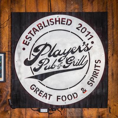 Wall with the logo and some surrounding memorabilia of Player's Pub & Grill