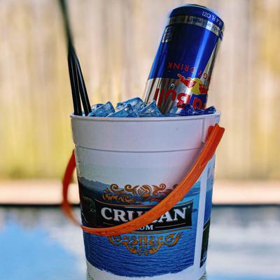 A bucket containing ice, and a can of energy drink.