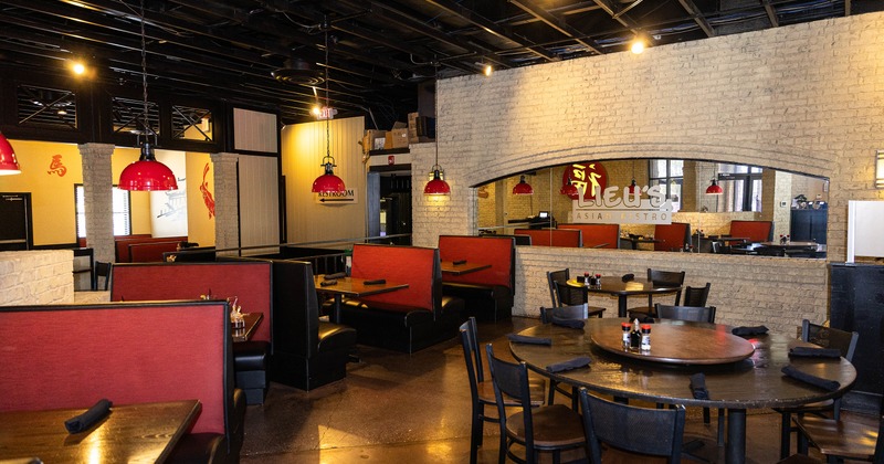 Spacious and cozy interior dining area with dining tables, chairs, and upholstered booths