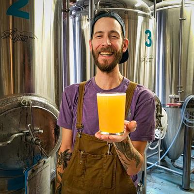 Staff member holding a glass of beer.