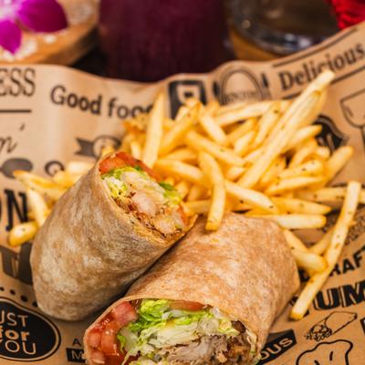 Chipotle Caesar Wrap sliced in half and served with fries.