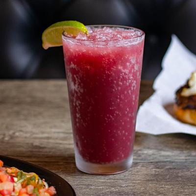 A table with food and a glass of Sangria garnished with a lime wedge.