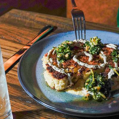 Roasted cauliflower steak with sauce and herbs