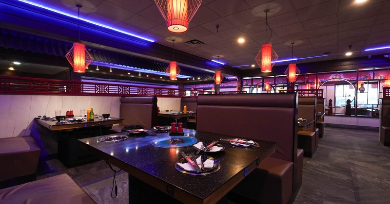 Interior, seating booths with grill tables, tile flooring, lanterns, room dividers