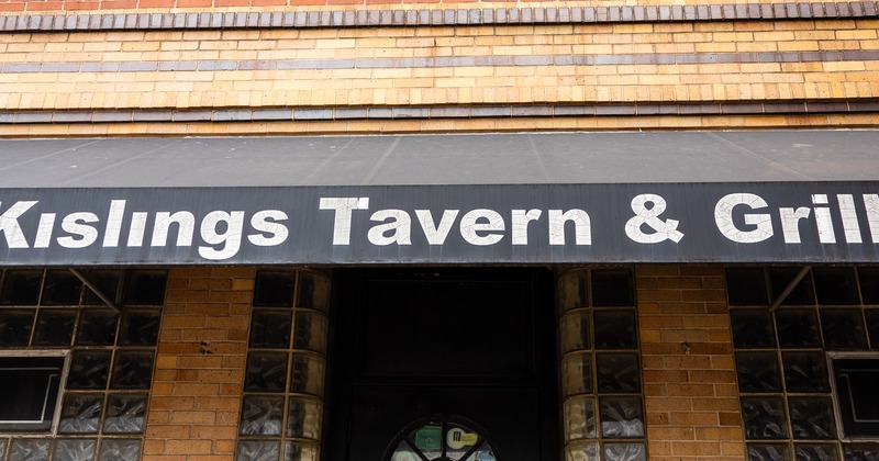 Exterior, front view to entrance, sign above