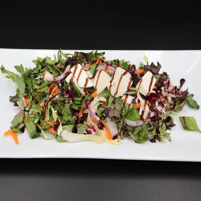 Greek Salad with mixed greens, tomatoes, cucumber, onions, olives, and feta.